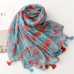 Detailed view of large floral print on cotton linen scarf with colorful edge tassels