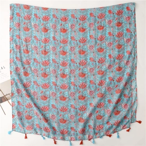 Detail of floral lotus pattern on light blue cotton linen scarf with colorful tassels