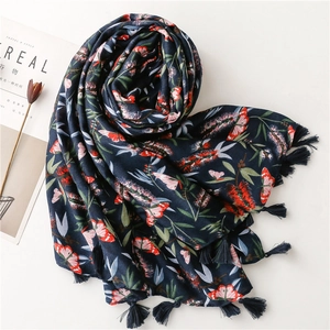 Detailed view of navy blue cotton linen scarf with floral print and handmade tassels