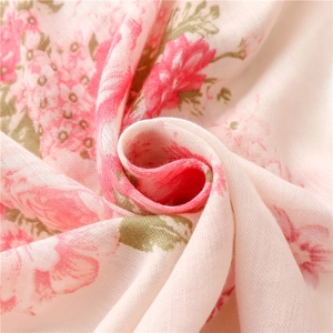 Detailed close-up of pink rose floral print on soft cotton linen scarf fabric