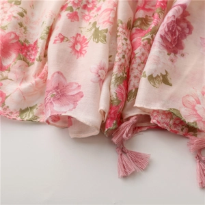 Detail of pink floral cotton linen scarf featuring delicate fringes and woven texture