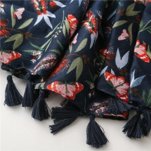 Close-up of navy blue linen scarf with red butterflies and floral patterns with tassels