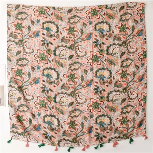 Bohemian floral scarf in light orange with ethnic patterns and tassels on white background