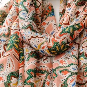 Close-up of coral paisley scarf showing ethnic floral patterns and cotton-linen texture