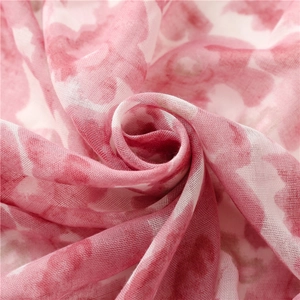Vue macro détaillée du motif floral aquarelle rose sur une écharpe légère en voile