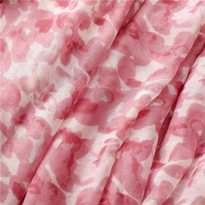 Gros plan sur le tissu bohème léger avec imprimé floral rouge et texture aquarelle douce