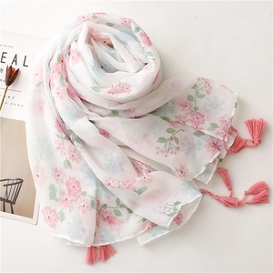 Floral print cotton linen scarf with pink tassels on a minimalist white background