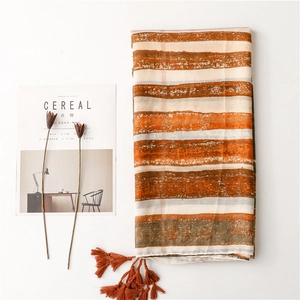 Bohemian striped shawl with gold stamping and tassels on a minimalist white background