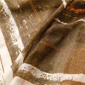 Detailed macro view of lightweight bohemian scarf with bronze stripes and ethnic texture