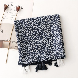 Dettaglio di uno scialle bohémien blu scuro con motivi floreali e nappe bicolori