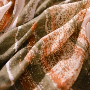 Macro view of bohemian scarf fabric with orange metallic foil and abstract stripes