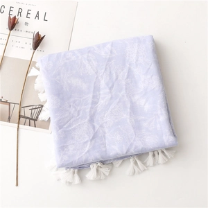 Detailed view of lavender cotton beach shawl with white floral prints and tassels