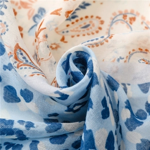 Macro detail of breathable linen cotton scarf with blue leopard and coral paisley prints