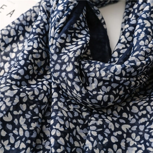 Dettaglio della sciarpa floreale blu navy con tessuto traspirante e piccoli petali