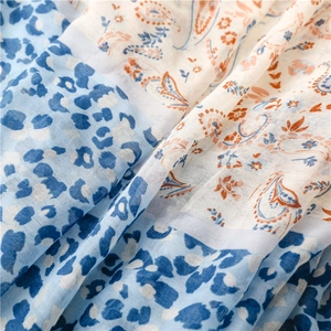 Detailed macro view of lightweight bohemian scarf showing leopard and paisley print textures