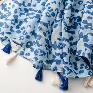 Close-up of blue leopard print scarf with cotton linen texture and fringe tassels