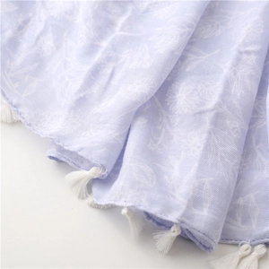 Detail of light purple bohemian beach scarf showing soft cotton texture and white tassels