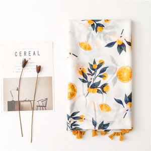 Lightweight scarf with orange citrus print and yellow tassels for sun protection