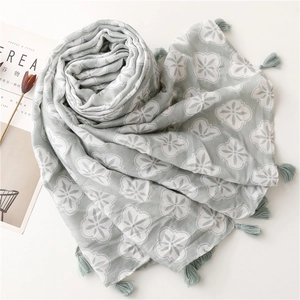 Close-up of light green floral scarf with delicate tassels and soft crinkle texture
