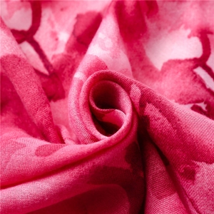 Macro detail of red rose floral print on soft woven fabric showing texture and drape