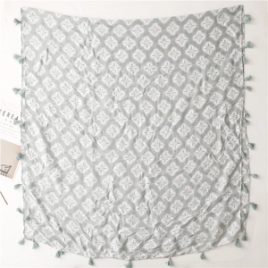 Detail of bohemian four-leaf floral scarf featuring grey fabric and tassel edge trim