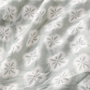 Macro detail of breathable sage green fabric with white floral pattern and woven texture