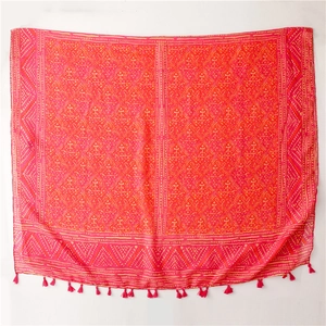 Detail view of red bohemian scarf with geometric prints and fringe tassels