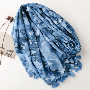 Detailed close-up of blue ink wash pattern scarf featuring elegant tassel fringe edges