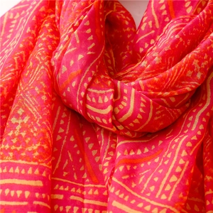 Detail of red Bohemian shawl showing lightweight fabric texture and geometric patterns