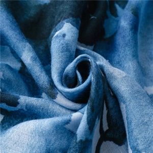 Detailed macro view of ink-wash floral print fabric with blue and white cotton texture