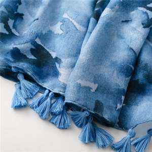 Detail of blue ink-wash gradient scarf featuring fabric texture and fringe tassels