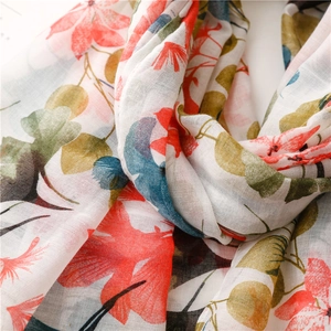 Gros plan d'une écharpe en coton et lin à fleurs montrant la texture douce du tissu
