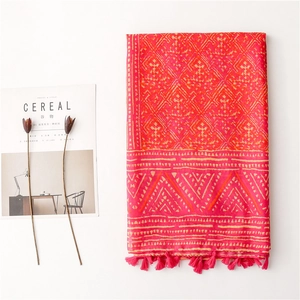 Bohemian style scarf with red geometric patterns and fringe tassels on minimalist background