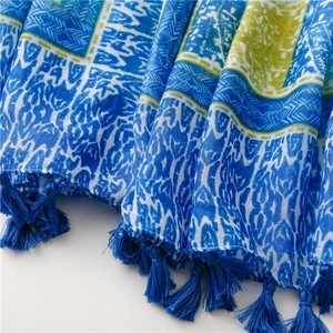 Detail of bohemian scarf with blue geometric patterns and soft tassel fringe texture