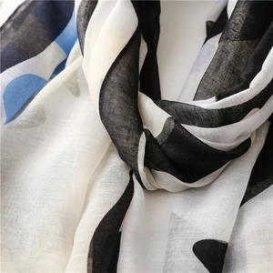 Lightweight scarf with black and white stripes and blue polka dots on soft fabric