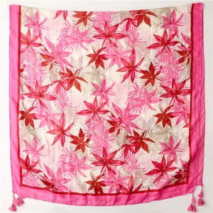 Détail de l'écharpe en coton et lin avec feuilles tropicales et pompons à franges