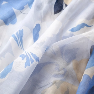 Dettaglio della stampa floreale blu e beige su tessuto morbido e traspirante in lino