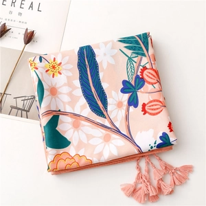 Close-up of floral print silk scarf with white daisies and elegant pink fringe details