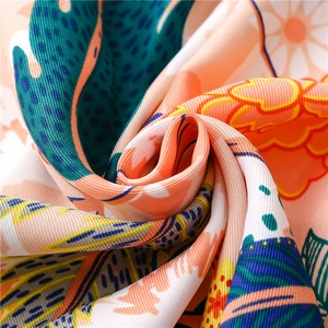 Macro shot of floral print silk scarf showing smooth texture and vivid digital patterns