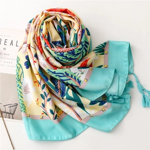 Detail of floral silk shawl featuring turquoise fringe and vibrant botanical print pattern