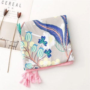 Detail of floral printed shawl featuring pink tassels and vibrant botanical patterns