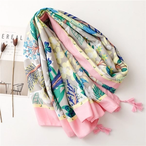 Detail of colorful floral silk scarf featuring pink tassels and green leaf print