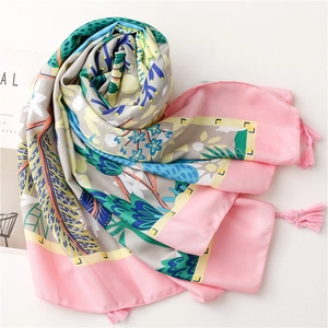Close-up of floral silk scarf with pink tassel fringe and intricate botanical pattern