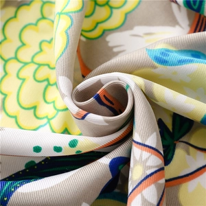 Detailed macro view of twill silk scarf with vibrant sunflowers and artistic patterns