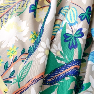 Macro view of twill weave silk scarf showing vibrant floral patterns and fine fabric texture