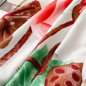 Detail of silk scarf showing lotus print on twill fabric with vibrant red and green colors