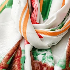 Close-up of silk scarf showing lotus print texture and soft flowing fabric folds