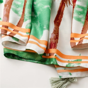 Detail of tropical palm print fabric with twill texture and orange striped border