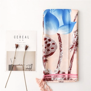 Detail of summer silk shawl with blue lotus print, tassels, and soft fabric texture