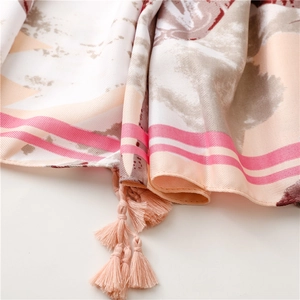 Detailed macro view of ethnic style scarf fabric with lotus patterns and pink tassel trim